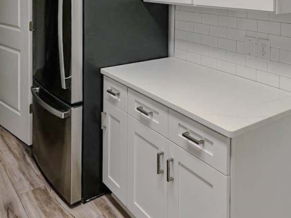 A black refrigerator with its door open in a kitchen.
