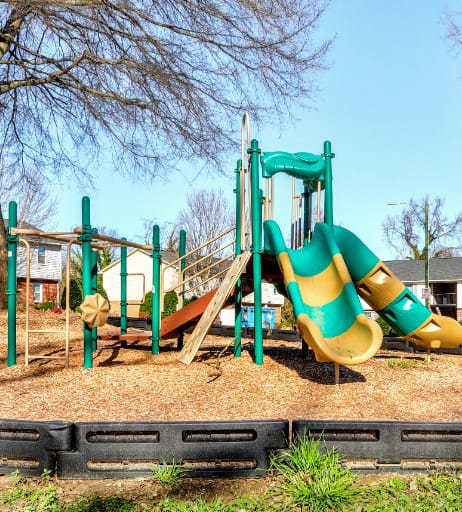 a playground with a large yellow and green slide at Trails Corner Apartments, North Carolina, 27610