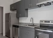 Thumbnail 14 of 24 - A modern kitchen with a stainless steel refrigerator, dishwasher, and oven.