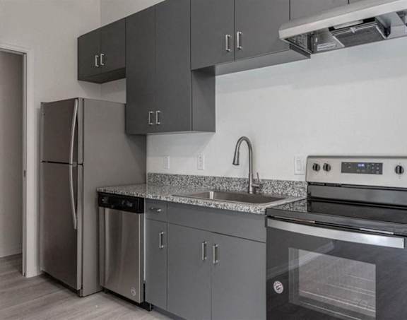 A modern kitchen with a stainless steel refrigerator, dishwasher, and oven.
