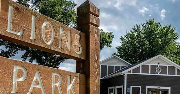a sign for lions park in front of a building
