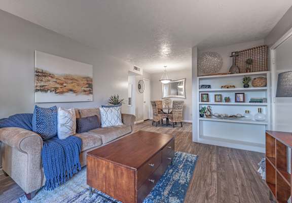 A living room with a brown sofa and a wooden coffee table. at Riverstone, Texas