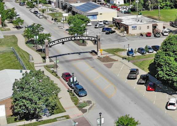 A city street with cars and a bridge in the background.