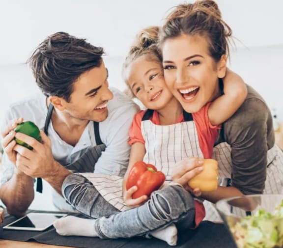 a man and a woman are sitting at a table with a young girl and a boy holding