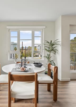 a dining room with a table and chairs and windows The Baxter in Los Angeles, CA 90028
