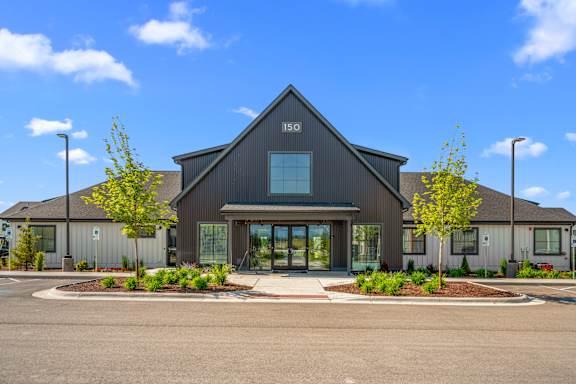 A modern building with a dark grey exterior and a large glass entrance.