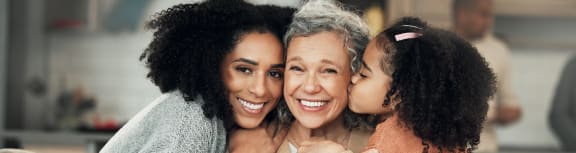 a woman sitting on a couch with her daughter and granddaughter