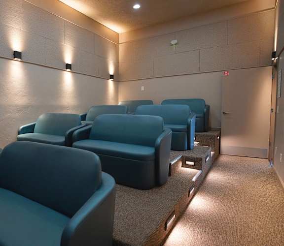 A row of blue seats in a dimly lit room.