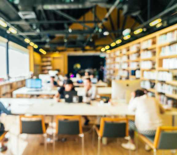 A group of people are sitting around a table in a library.