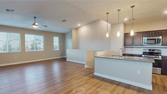 an empty living room and kitchen with a counter top