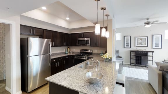 A kitchen with a granite countertop and stainless steel appliances.