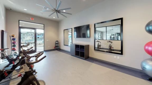 a workout room with bikes and mirrors in a home gym