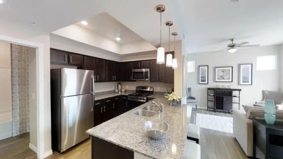 A kitchen with a granite countertop and stainless steel appliances.