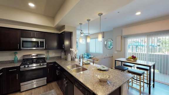 A kitchen with a granite countertop and stainless steel appliances.