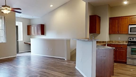 an empty kitchen and living room with wood flooring