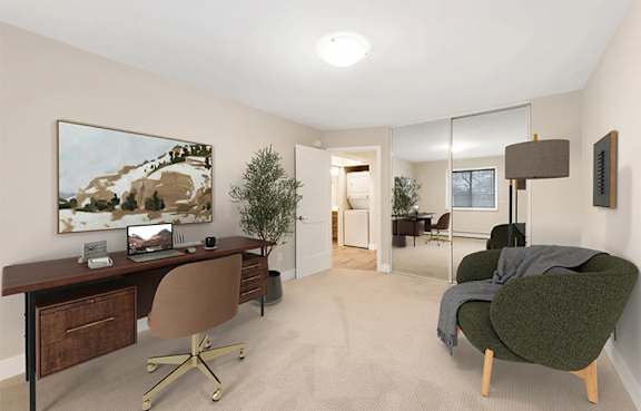 A room with a desk, chair, and a painting on the wall.