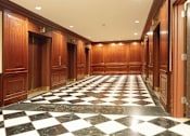 Thumbnail 16 of 23 - A long hallway with a black and white checkered floor.