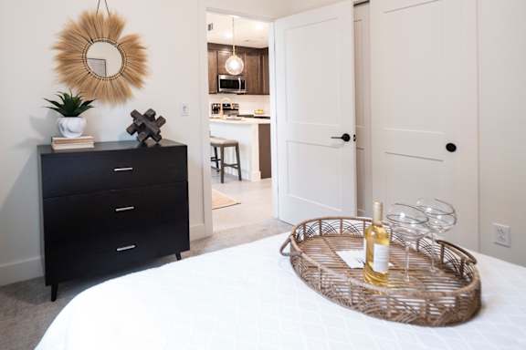 a bedroom with a bed and a dresser with a mirror on the wall