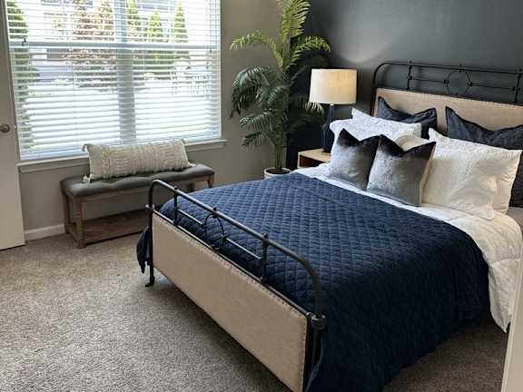 a bedroom with a bed and two windows