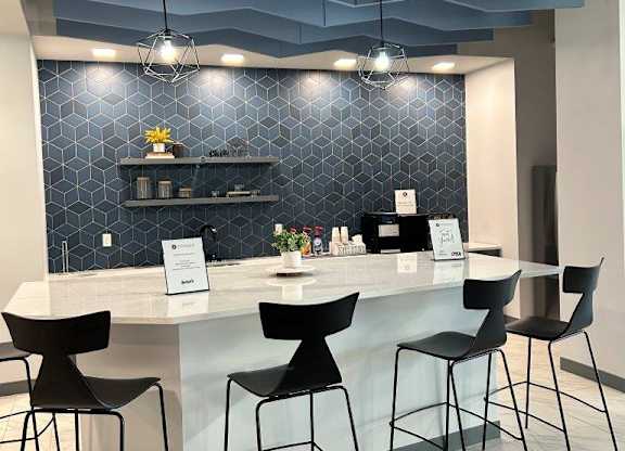 a lobby with a counter and chairs and a blue ceiling at The Residences at Tesson Ridge, Saint Louis, 63128