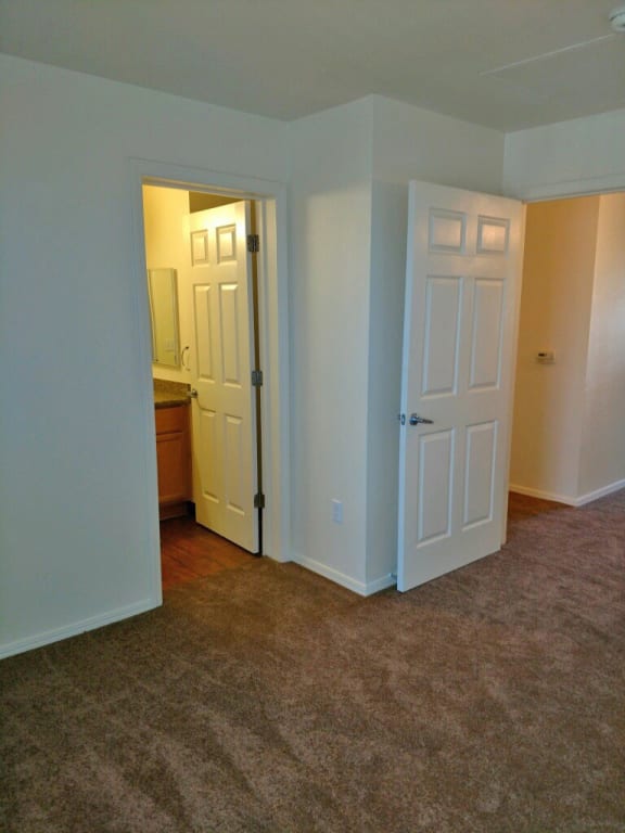 First bedroom facing entrance to hall and bathroom.  Flooring is carpet.
