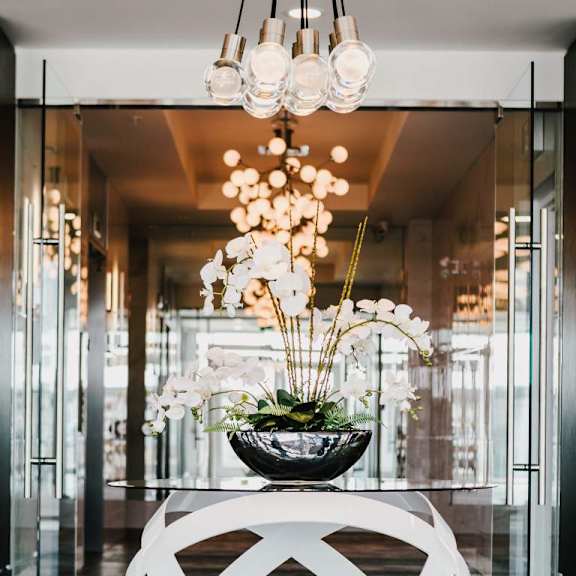 A white couch is in the middle of a room with a large chandelier hanging from the ceiling.