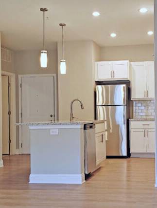 A kitchen with a white island and stainless steel appliances.