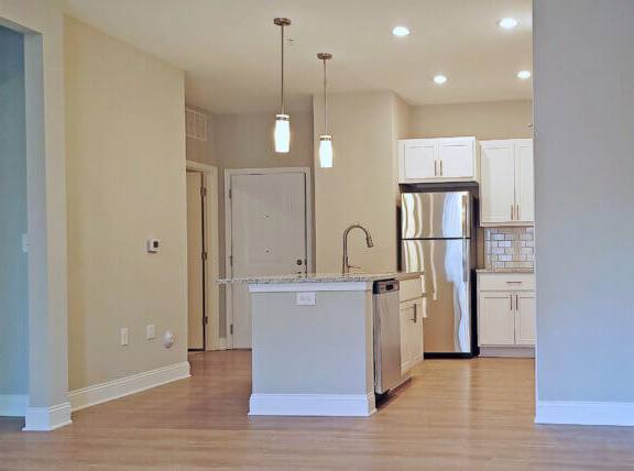 A kitchen with a white island and stainless steel appliances.