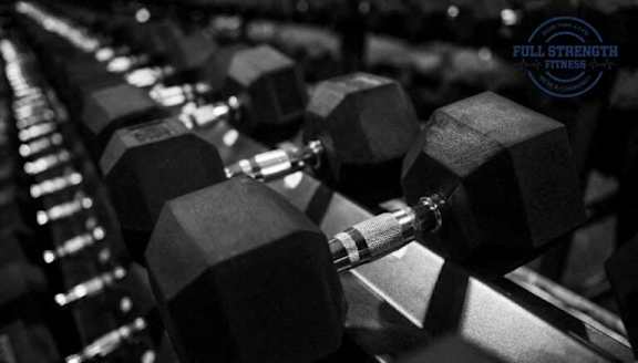 A close-up of a dumbbell in a gym setting.