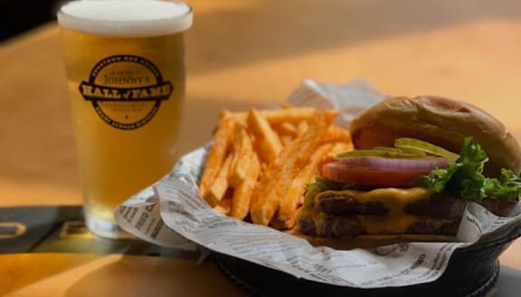 A burger and fries with a glass of beer.