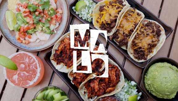 A variety of Mexican food including tacos and guacamole.