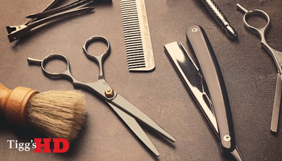 A collection of hairdressing tools including scissors, combs, and a brush.
