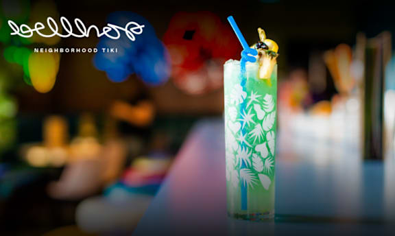 A glass of a green beverage with a straw in it.