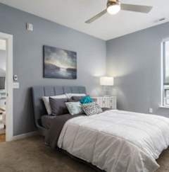 a bedroom with a bed and a ceiling fan