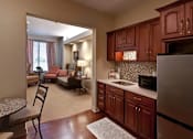 Thumbnail 11 of 12 - A kitchen with wooden cabinets and a refrigerator.