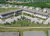 Thumbnail 3 of 12 - A large building with a courtyard in the middle of a grassy area.