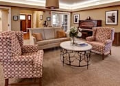 Thumbnail 7 of 12 - A living room with patterned chairs and a sofa.