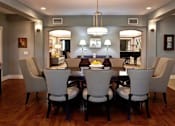 Thumbnail 9 of 12 - A dining room with a large table and chairs.