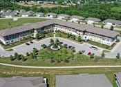 Thumbnail 1 of 5 - A large building with a circular courtyard in the middle of a grassy area.
