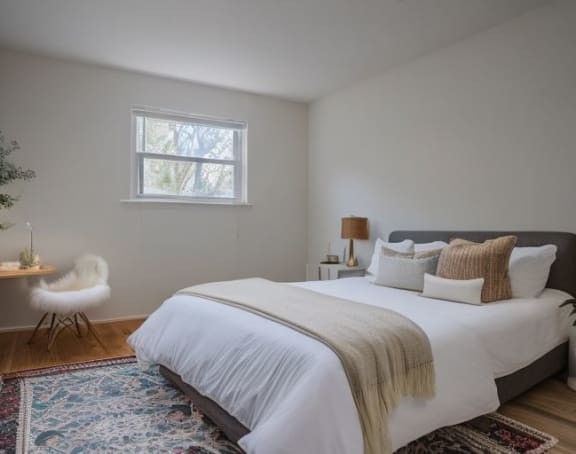 a bedroom with a bed and a desk and a window