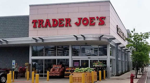 A Trader Joe's store with a parking lot in front.