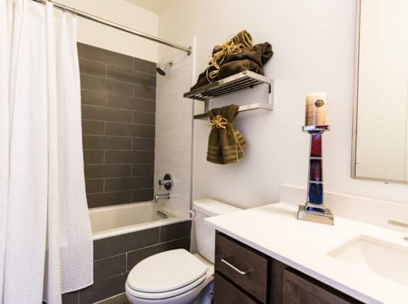 A bathroom with a white toilet, a white shower curtain, and a white sink.