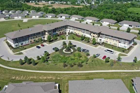 A large building with a courtyard in the middle of a grassy area.