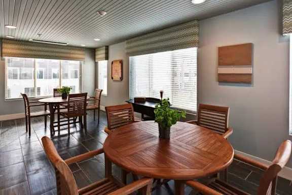 A wooden table with chairs around it in a room with a window.