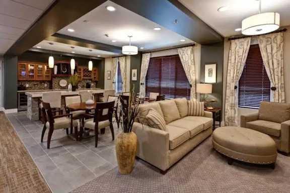 A living room with a grey carpet and a beige sofa.