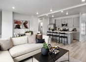Thumbnail 10 of 17 - A modern living room with a white sofa and a black coffee table.
