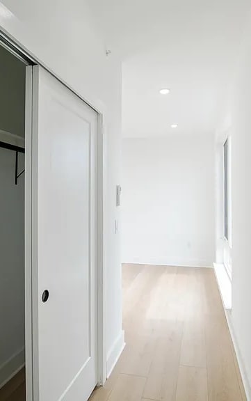 A white door is at the end of a hallway.