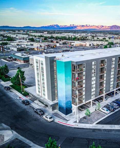 A modern building with a blue glass facade is the main focus of the image.