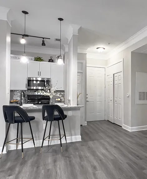 A kitchen with white cabinets and a black countertop.