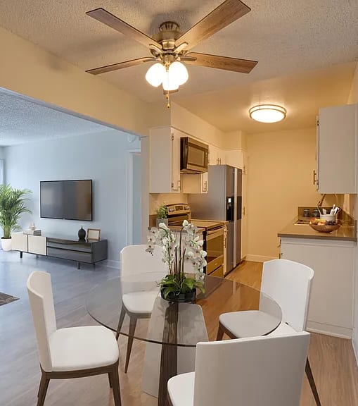 A well-lit, modern kitchen and living room with a dining area.